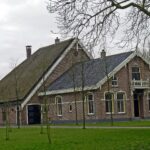 Boerderij van het kop-romp-type, gesitueerd aan de zuidzijde van de dorpsweg