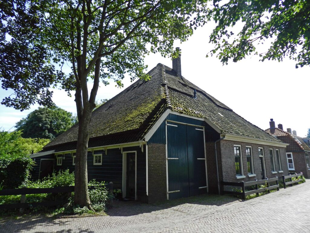 Stolphoeve met door riet en pannen gedekt dak